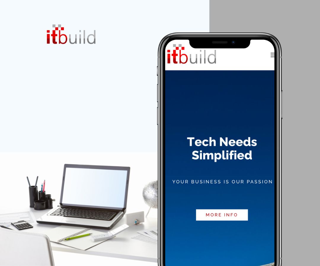 A large smartphone displayed on the right showing a blue screen with the text “Tech Needs Simplified” and a smaller line “Your Business Is Our Passion.” On the left side, there is a simple workspace with a laptop, desk items, and a chair, set against a light neutral background.